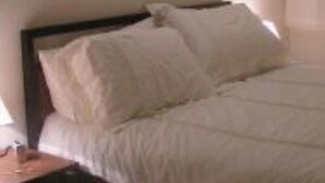 A neatly made bed with white linens in a room with two framed pictures on the wall. - Charming 2-bedroom apartment with WiFi, AC in fantastic Platja de l'Arenal (Platja de l'Arenal)