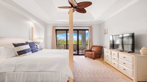 A bedroom with a bed, a TV, a chair, and a balcony with curtains. - Coastal Paradise Awaits: Luxurious Beachside House with Top-Notch Amenities (Marco Island)