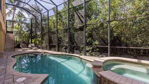 Ein Pool mit Glasveranda, umgeben von Bäumen und einer Terrasse mit Stuhl und kleiner Treppe.