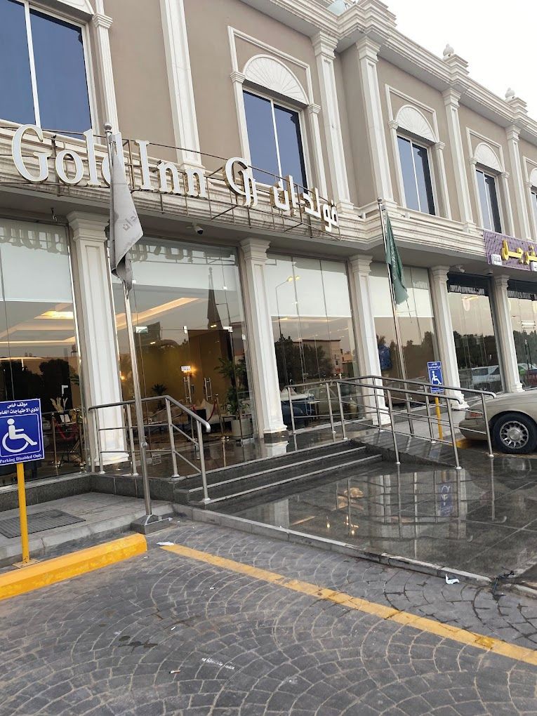 A hotel entrance with a sign reading "Gold Inn & Suites".