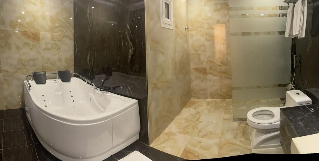 A modern bathroom with a freestanding bathtub, a glass-enclosed shower, and a toilet.