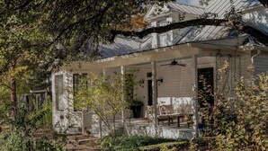 A white house with a covered porch, a visible window, and a door.