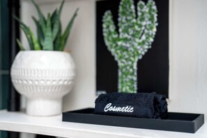 A black tray with a black towel labeled "Cosmetic" on a white shelf.