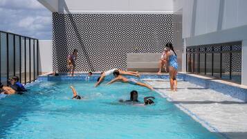 Una piscina al aire libre, sillones reclinables de piscina