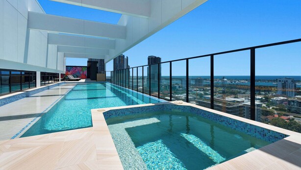 A rooftop infinity pool with a city view, large windows, and a modern architectural design.