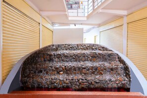 A stone water feature with cascading water in a modern indoor setting. - Treebo Regalia Comforts, 5 mins to Raja Seat Garden (Madikeri)