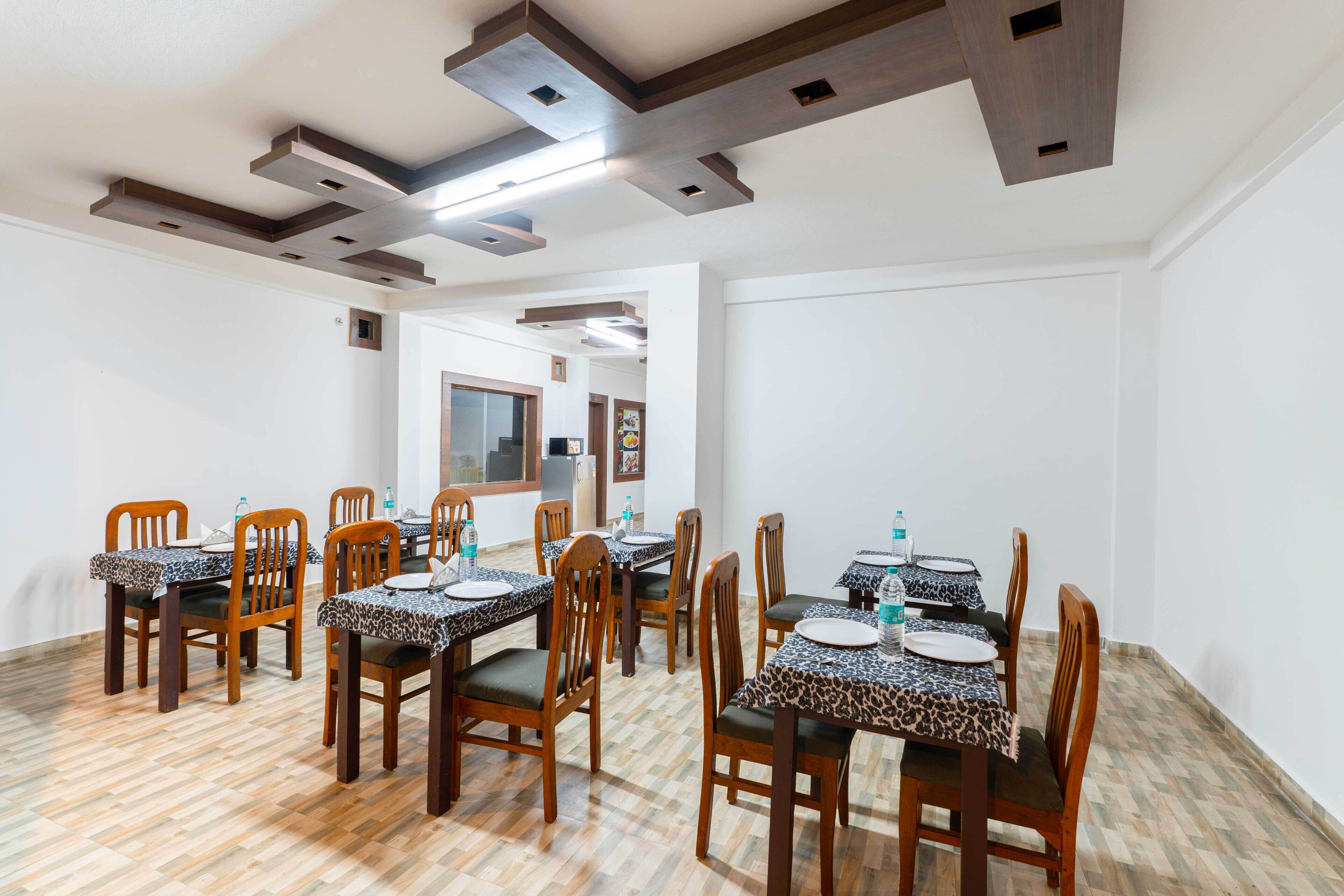 A dining area with wooden chairs and tables, some with leopard print tablecloths.