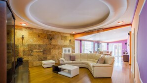 A spacious living room with a large L-shaped sofa, a coffee table, and a stone accent wall.