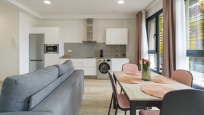 Una cocina moderna con horno empotrado, microondas y lavadora.