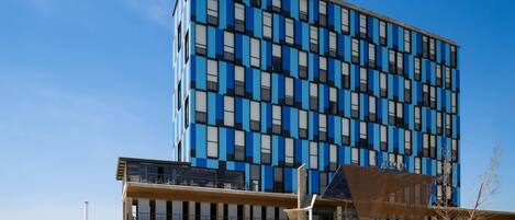 Un moderno edificio de hotel con fachada azul y blanca, que dice 'UTTSA INN'.