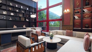 A modern interior with a large window, a sofa, a coffee table, and a bookshelf. - Days Hotel By Wyndham Aba Jiuzhaigou (Ngawa Autonomous Prefecture)