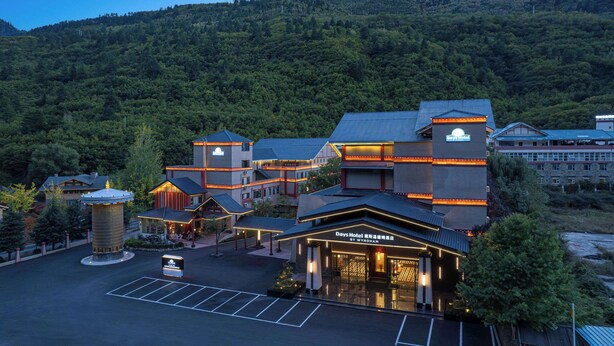 A hotel with a modern architectural design, featuring multiple buildings with distinct roofs and a central courtyard. - Days Hotel By Wyndham Aba Jiuzhaigou (Ngawa Autonomous Prefecture)