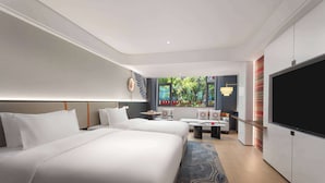 A hotel room with two beds, a TV, a seating area, and a view of greenery outside. - Days Hotel By Wyndham Aba Jiuzhaigou (Ngawa Autonomous Prefecture)
