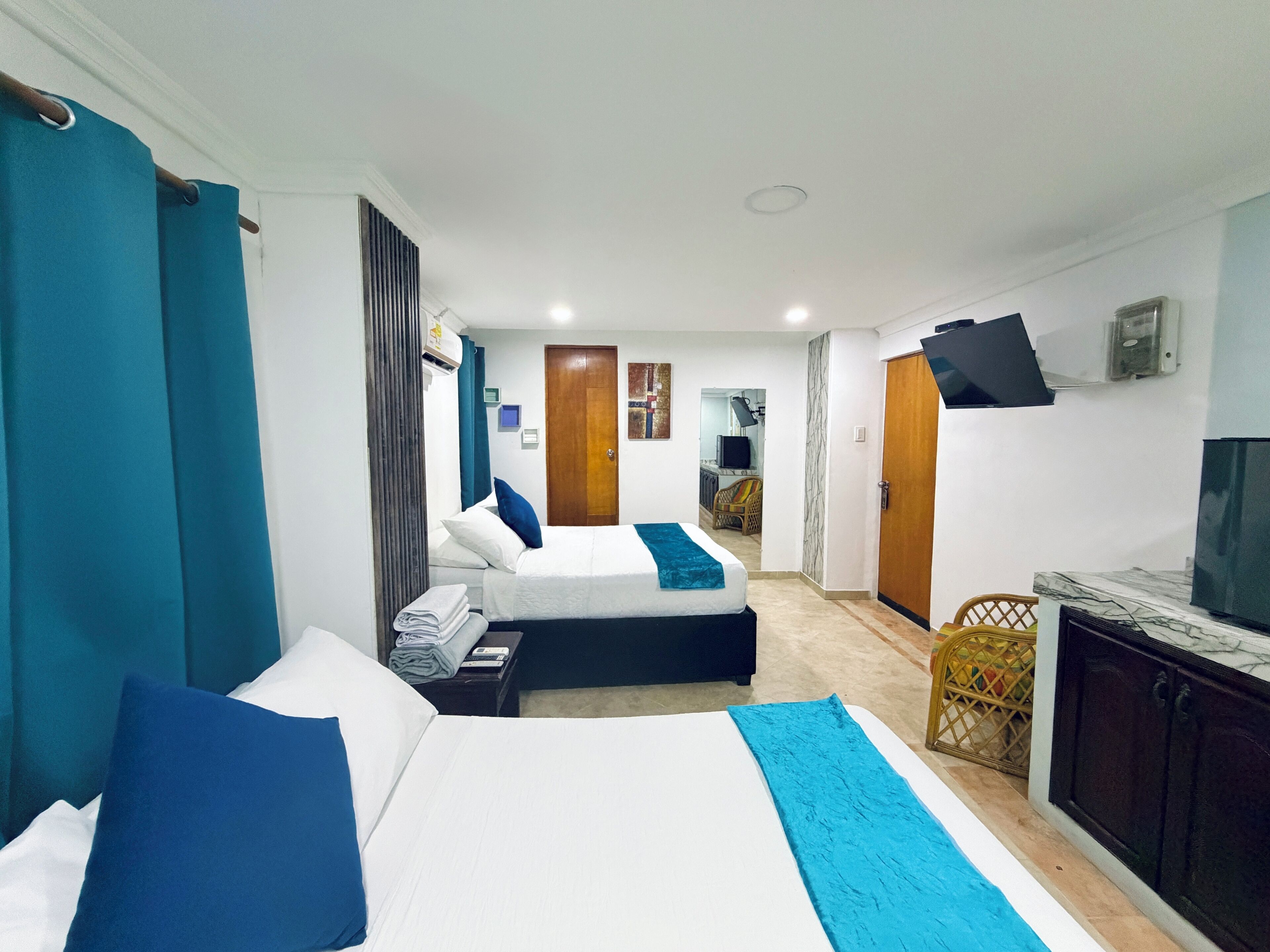 Ein Hotelzimmer mit zwei Betten, einem Schreibtisch, einem Fernseher und einer Minibar.