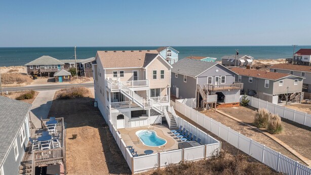 Une propriété située en bord de mer, dotée d’une piscine, de plusieurs terrasses et offrant une vue sur l’océan.
