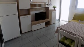 A compact living space with a kitchenette, a television, a dining table, and a sofa. - Trogir Sunny Apartments with Sea View - Standard Two bedroom Apartment with Sea view and Balcony (Trogir)