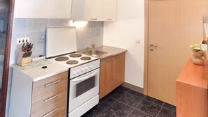 A compact kitchen with a stove, sink, and cabinets. - Trogir Sunny Apartments with Sea View - Standard Two bedroom Apartment with Sea view and Balcony (Trogir)