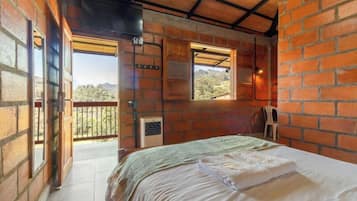 Una habitación con cama, ventana y balcón.