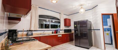 Una cocina con estufa, refrigerador y armarios.
