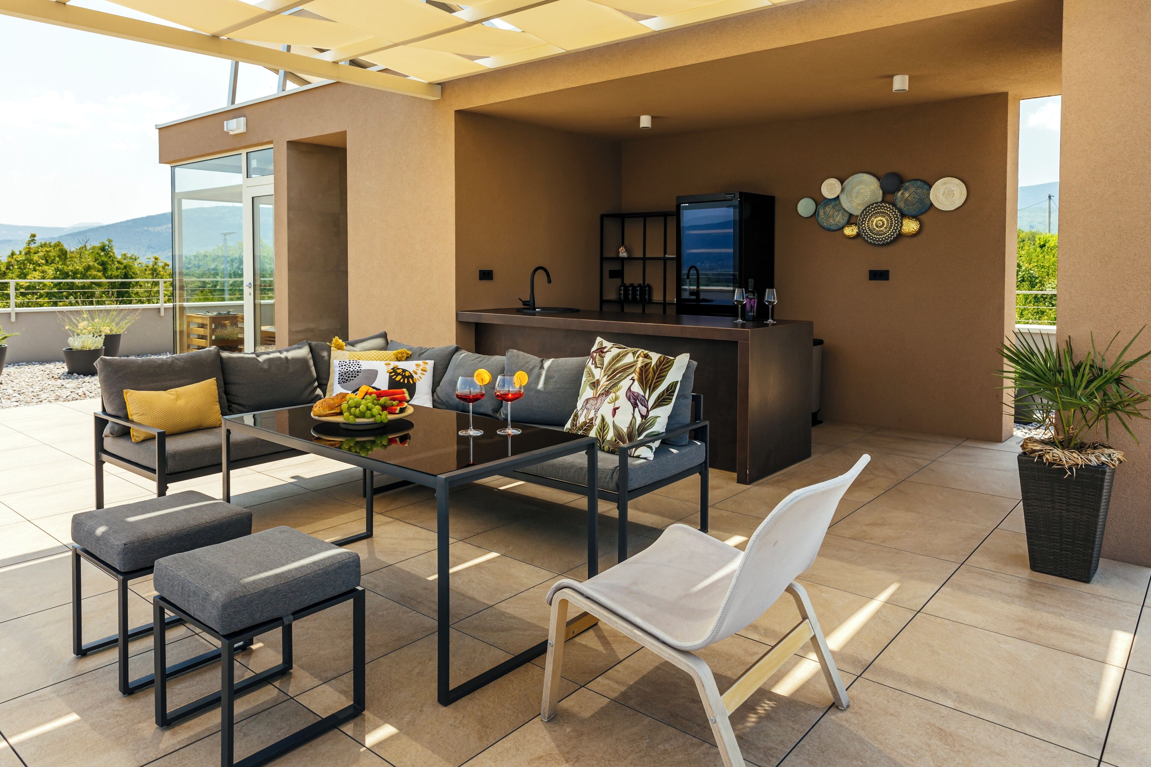 A modern outdoor living area with a sofa, chairs, and a coffee table.