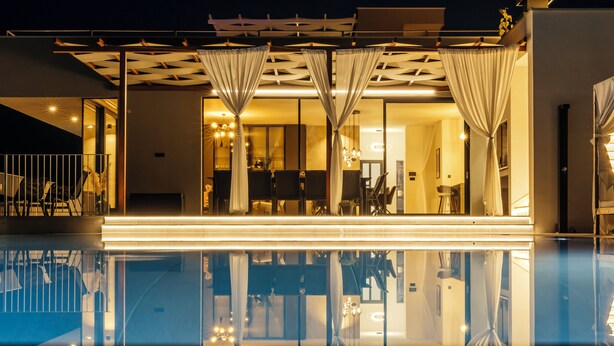 Un hôtel moderne doté d’une piscine, de grandes fenêtres et d’un intérieur bien éclairé.