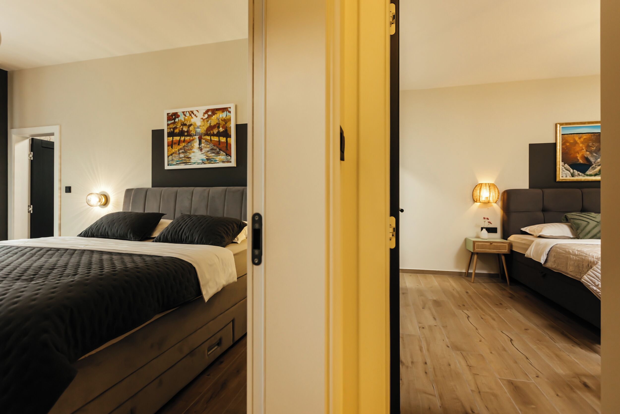Een slaapkamer met een bed, nachtkastjes en kunstwerken aan de wanden.