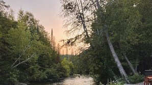 Ein Garten am Flussufer mit Holzkästen und einer Holzterrasse.