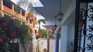 A narrow corridor with patterned tile flooring, a red carpet, and a white wall with a decorative column. - Relaxing getaway, Studio between Béjaïa and JIJEL (Ziama Mansouriah)