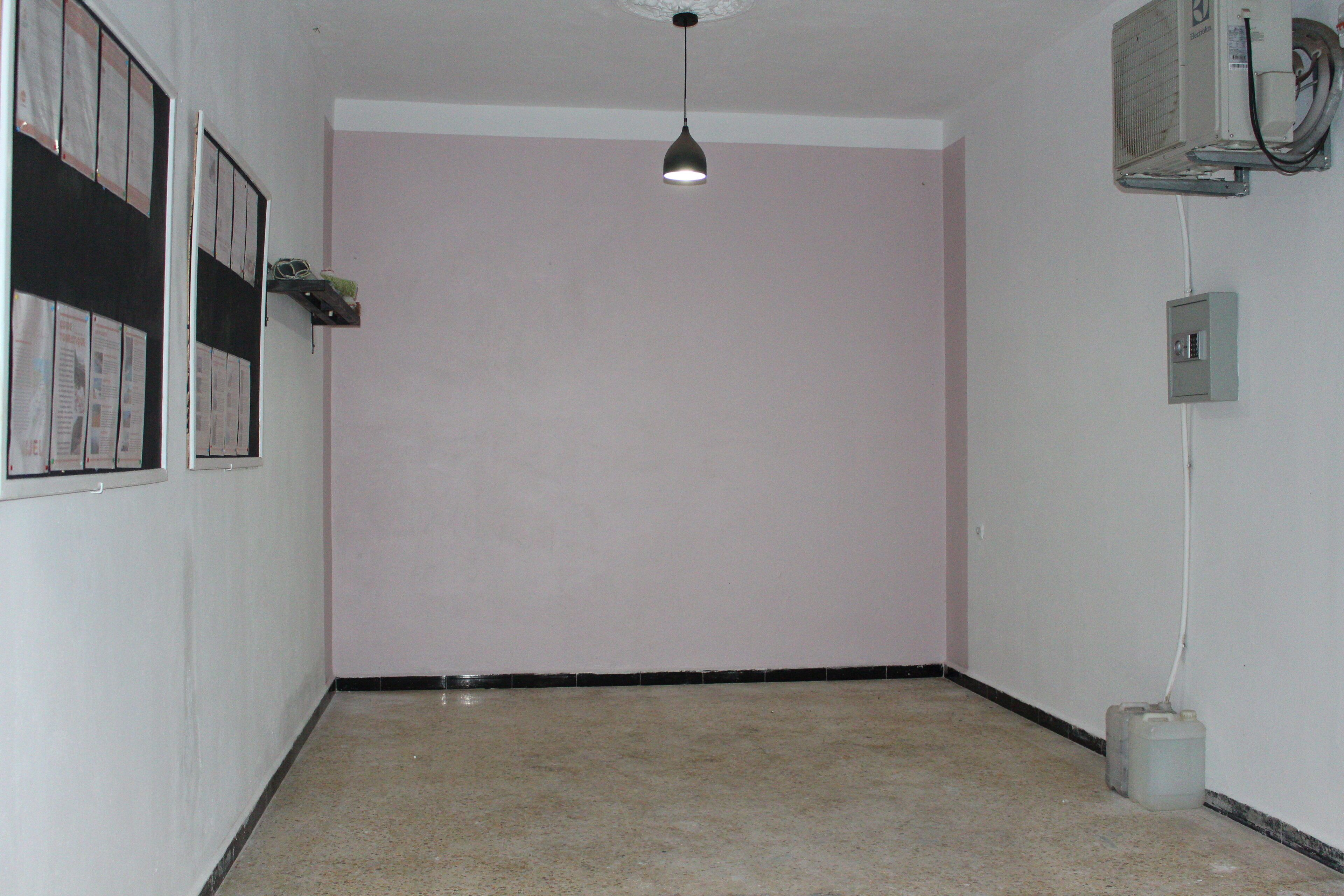 Un couloir avec un ventilateur de plafond, un luminaire et un climatiseur fixé au mur.