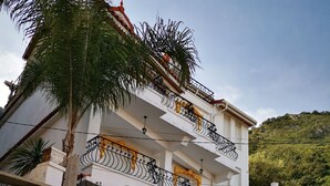 A two-story building with a gated entrance, a stone pillar, and a red-tiled ground floor. - Relaxing getaway, Studio between Béjaïa and JIJEL (Ziama Mansouriah)
