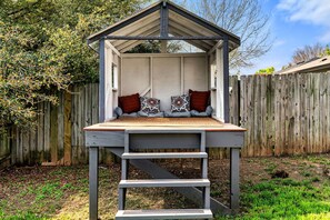 A wooden deck with a bench and a small shelter.