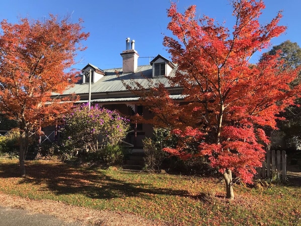 A house with a gabled roof, a chimney, and a front porch.