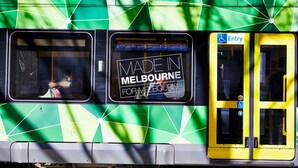 A bus with a green and white geometric pattern and a sign that reads "MADE IN MELBOURNE FOR MELBOURNE". - Mr Clarke - Prime Cityscape with Parking (Southbank)