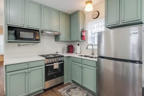 Een magnetron, een oven, een kookplaat, keukenrol