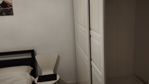 Ein Schlafzimmer mit Bett, Stuhl und Kleiderschrank.