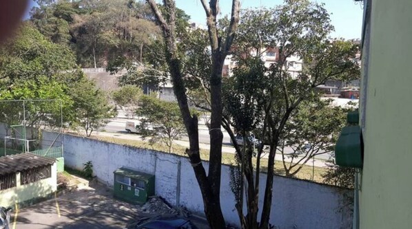 Overlooking a serene street scene with trees and a nearby building.