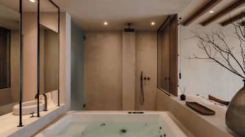 A modern bathroom with a large bathtub, a shower, and a vanity area.