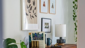 A wooden dresser with drawers, a lamp, framed pictures, and a potted plant. - Cuyahoga Valley National Park, Hiking,Dog Friendly (Brecksville)