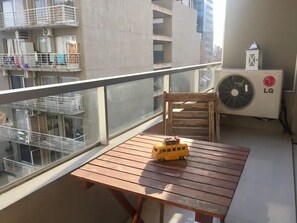Enjoy a peaceful balcony with a table and chair, perfect for taking in the views of the surrounding neighborhood.