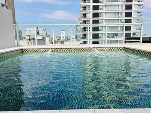 Enjoy a refreshing swim in the rooftop pool surrounded by a tiled edge.