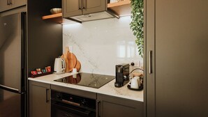 A modern kitchen with a built-in oven, a coffee maker, and a toaster. - The Kings Domain - Luxurious townhouse in the CBD (Blenheim)
