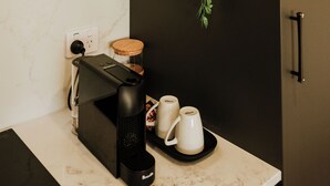 A kitchen with a coffee machine, a tray with two cups, and a hanging plant. - The Kings Domain - Luxurious townhouse in the CBD (Blenheim)
