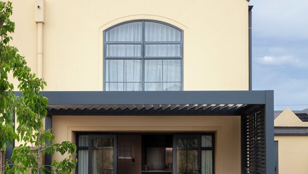 A modern house with a wooden deck leading to a covered outdoor seating area with a sofa and a table. - The Kings Domain - Luxurious townhouse in the CBD (Blenheim)