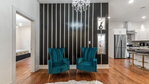 Eine moderne Küche mit Edelstahlgeräten, einer Bar inklusive Barhocker und einer Kristallleuchtre.'
