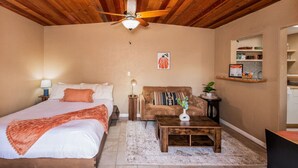 A bedroom with a bed, a sofa, a coffee table, a ceiling fan, and a small side table. - Private Serene Escape with Patio and Fenced Yard in West Sedona (Sedona)