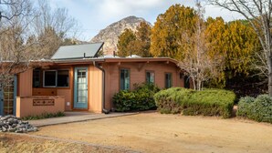 A single-story house with a sloped roof, a front door, and a small front yard with a gravel path. - Private Serene Escape with Patio and Fenced Yard in West Sedona (Sedona)