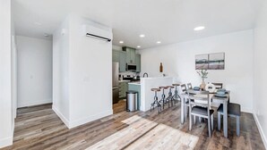 A modern kitchen with a central island, bar stools, and a dining table with chairs. - High-end, convenient, new build! (Juneau)
