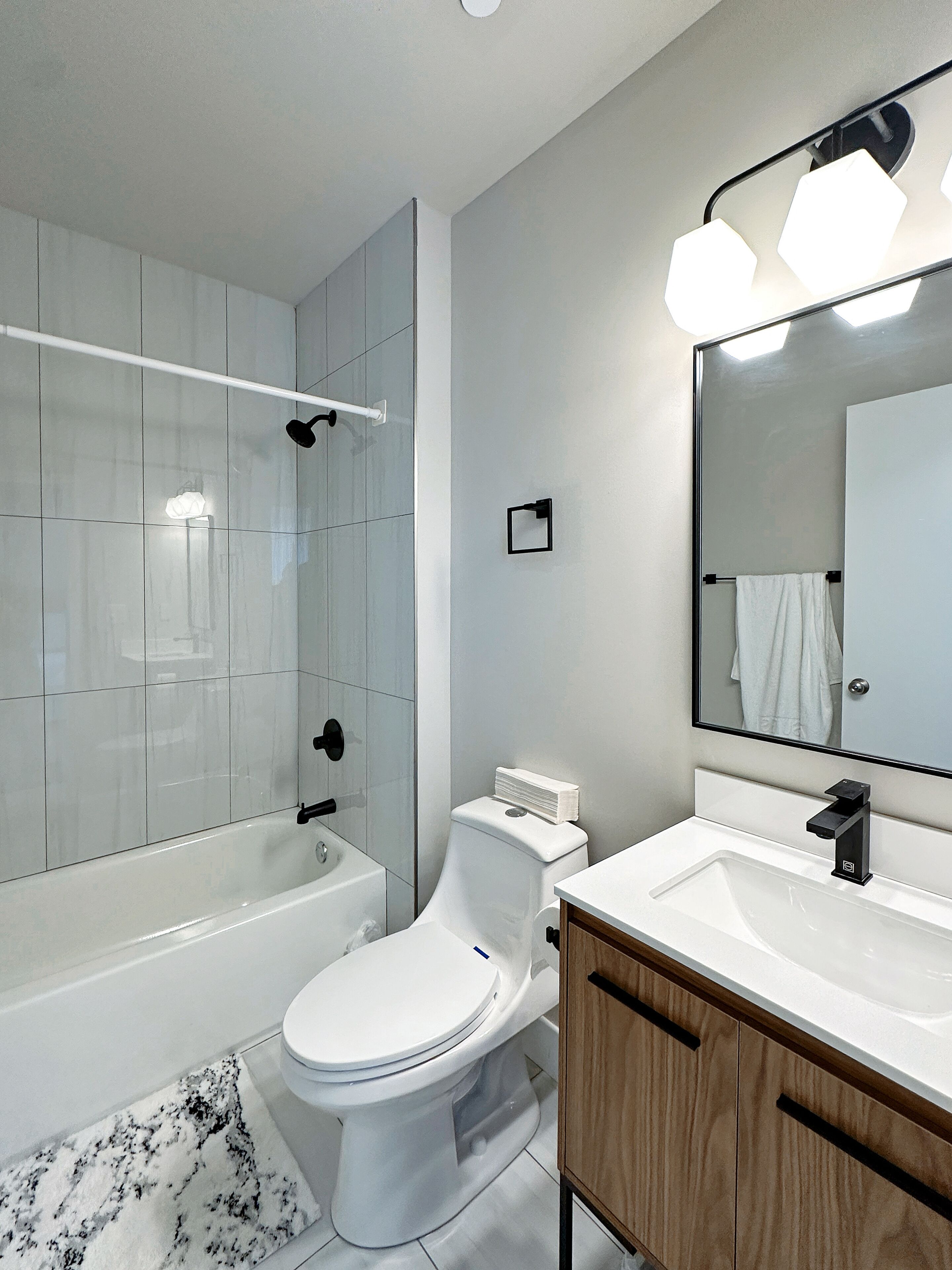 Een moderne badkamer met een badkuip, toilet en wastafel.