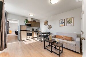 Um apartamento moderno com cozinha, sala de jantar e sala de estar.