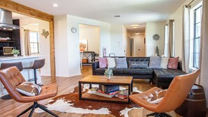 A living room with a sofa, two armchairs, a coffee table, and a cowhide rug. - Hot Tub Retreat by Wine Country (Fredericksburg)